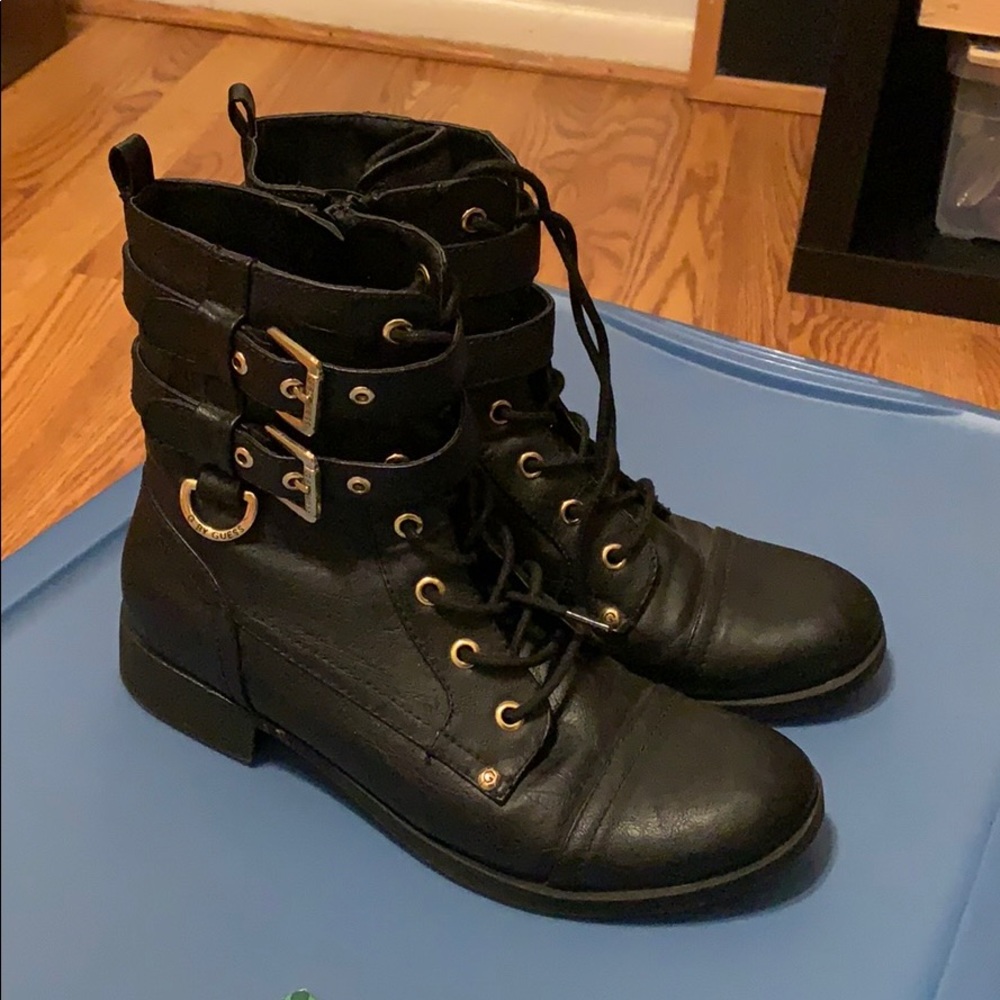 Boots that are black leather with golden buckles
